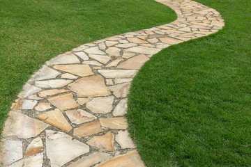Kamienna ścieżka na zielonej trawie w ogródzie - 236551703