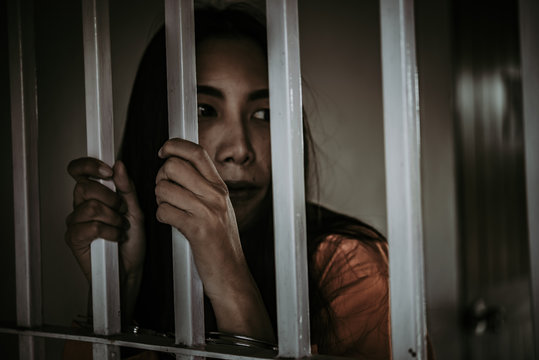 Portrait of woman desperate to catch the iron prison,prisoner concept,thailand people,Hope to be free.
