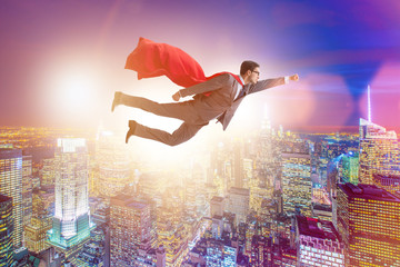 Obraz na płótnie Canvas Superhero businessman flying over the city