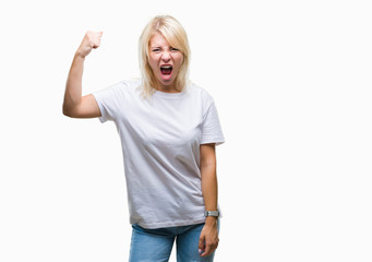 Young beautiful blonde woman wearing white t-shirt over isolated background angry and mad raising fist frustrated and furious while shouting with anger. Rage and aggressive concept.