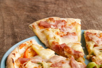 Hot pizza slice on wooden table
