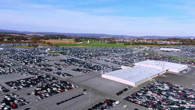 Aerial view on parking lot of Worlds largest used cars auction packed with hundreds of vehicles in Manheim, Pennsylvania. Forward dolly move, daylight, high angle