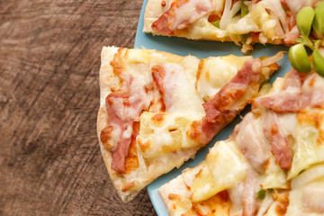 Hot pizza slice on wooden table