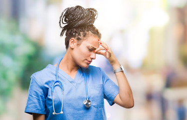 Young braided hair african american girl professional surgeon over isolated background tired rubbing nose and eyes feeling fatigue and headache. Stress and frustration concept.