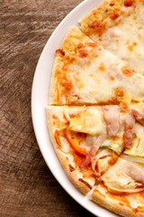 Hot pizza slice on wooden table