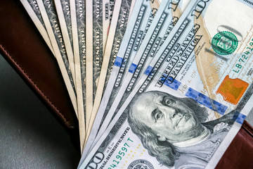 Closeup view of wallet with one hundred and fifty dollar banknotes.