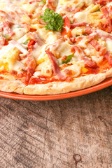 Hot pizza slice on wooden table