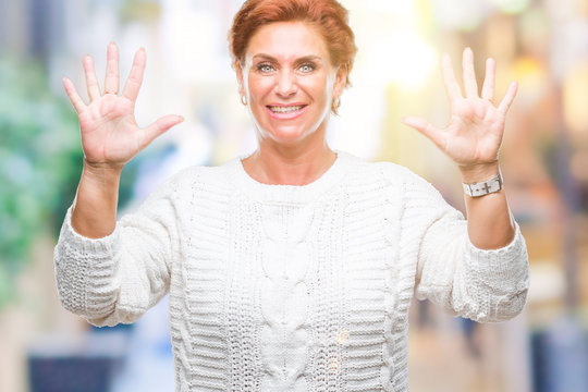 Atrractive senior caucasian redhead woman wearing winter sweater over isolated background showing and pointing up with fingers number ten while smiling confident and happy.