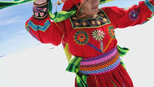 Traditional Bolivian dancing performed proudly by Indigenous South American female on Salar de Uyuni Salt flats wearing traditional costume 