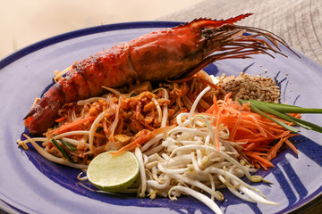 Hot Pad thai with shrimp on wooden table