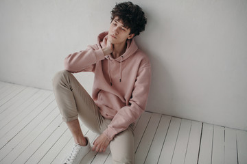Young stylish man sitting on floor
