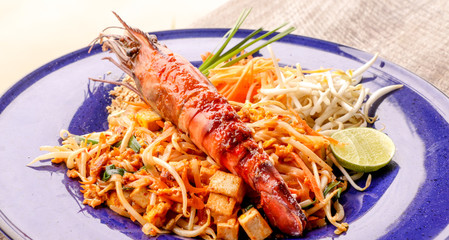 Hot Pad thai with shrimp on wooden table