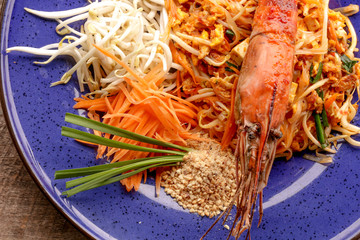 Hot Pad thai with shrimp on wooden table