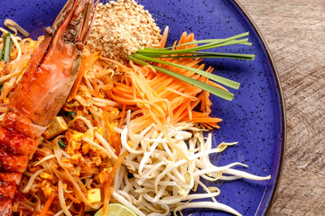 Hot Pad thai with shrimp on wooden table