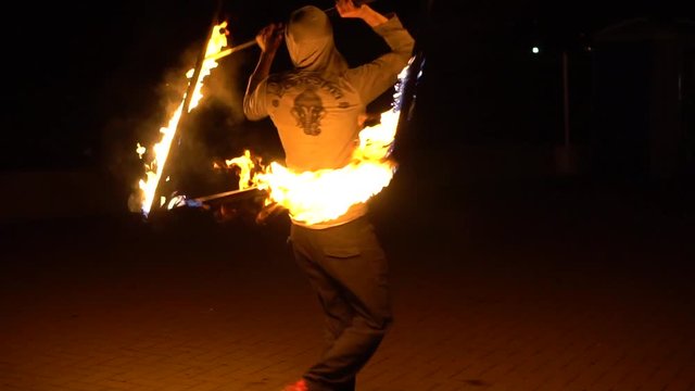 Slowmotion shot of man spinning unusual square fire prop