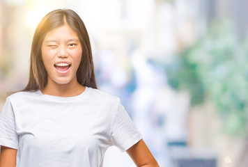 Young asian woman over isolated background winking looking at the camera with sexy expression,...