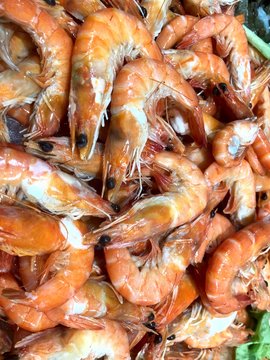 Large orange fresh shrimps on the storefront in the store. Cropped shot, close-up, a lot, top view. The concept of nutrition and health.