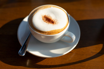 Cappuccino coffee hot in wooden background.