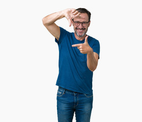 Fototapeta premium Handsome middle age hoary senior man wearin glasses over isolated background smiling making frame with hands and fingers with happy face. Creativity and photography concept.