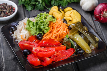 Assorted pickled vegetables - Sauerkraut cabbage, watermelon, peppers, cucumbers, tomatoes and herbs on light wooden background. Snacks and Wine appetizers set. Ingredients on table