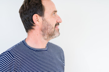 Fototapeta premium Handsome senior man over isolated background looking to side, relax profile pose with natural face with confident smile.