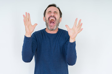 Fototapeta premium Elegant senior man over isolated background celebrating mad and crazy for success with arms raised and closed eyes screaming excited. Winner concept