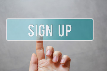 Sign up - finger pressing blue transparent button on virtual touchscreen interface on gray background with copy space for text. Internet networking business and social media concept.