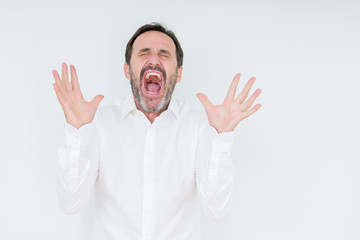 Fototapeta premium Elegant senior man over isolated background celebrating mad and crazy for success with arms raised and closed eyes screaming excited. Winner concept