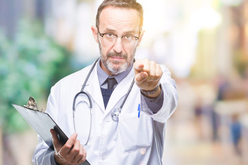 Middle age senior hoary doctor man holding clipboard over isolated background pointing with finger to the camera and to you, hand sign, positive and confident gesture from the front