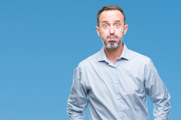 Middle age hoary senior business man over isolated background puffing cheeks with funny face. Mouth...