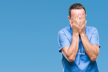 Middle age hoary senior doctor man wearing medical uniform over isolated background with sad expression covering face with hands while crying. Depression concept.