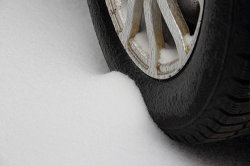 Winter driving a car, preparing for the trip - wheel on aluminium disc close up in the snow