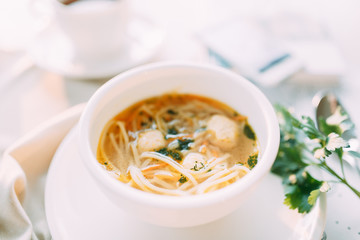 Soup with greens, mushrooms and noodles with chicken. Restaurant dishes with a beautiful serving.