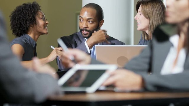 Group of multi ethnic business people using app touchscreen technology meeting in atrium modern office building 