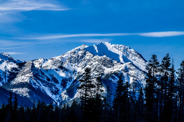 Mountains and trees starting their early spring thaw from Barrier Lake, Bow Valley Provincial Park,...