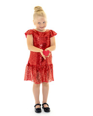 A little girl is holding a heart.