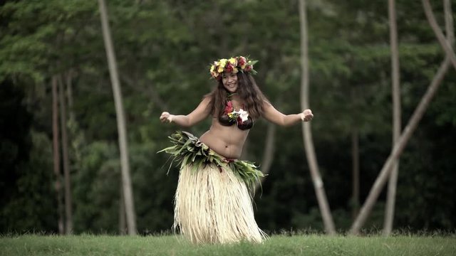 Single beautiful young Polynesian female hula dancer in Paradise entertaining in traditional costume barefoot outdoor French Polynesia South Pacific