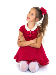 The little girl is on her knees.