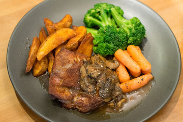 sous vide chicken chop with potato wedges and baby carrot broccolli