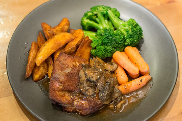 sous vide chicken chop with potato wedges and baby carrot broccolli