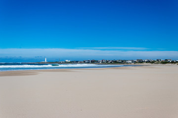 Beach and sea with lighthouse in distance