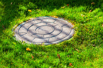 Sewer manhole on a  lawn.