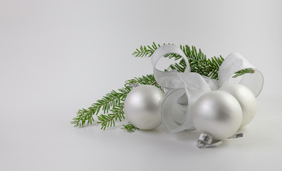 Christmas tree branch with wide silver bow and rounded silver ornaments