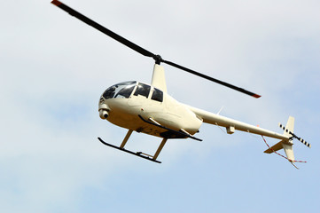 helicopter flying in the sky / white helicopter flying air with camera taking pictures