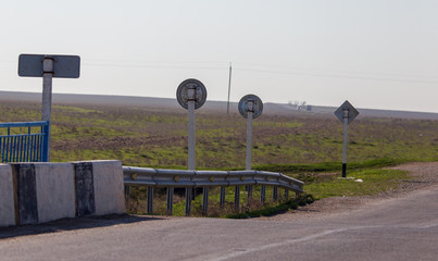 Metal road sign stands near the road