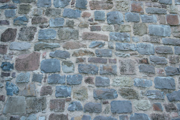 Obraz premium Mauer aus Naturstein in grau rot und blau mit grauen Fugen Vulkangestein
