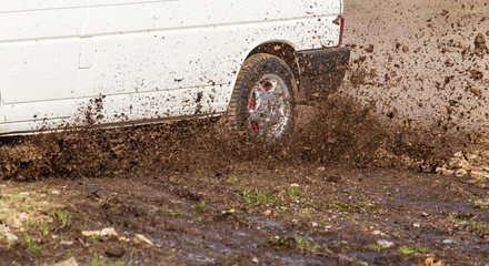 Fototapeta na wymiar Soil and dirt flies out from under the wheels of a car