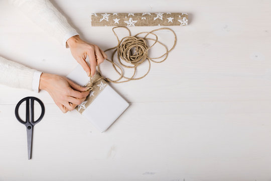 Female hands prepare a gift package