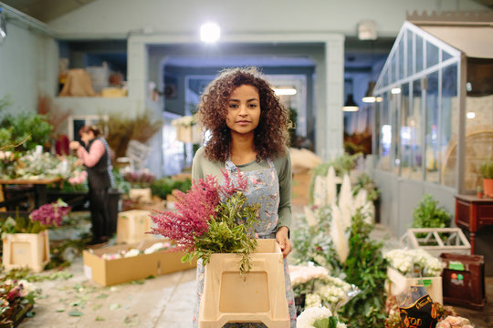 Woman with box of flowers in shop