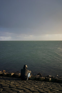 Young man in the rain at sea